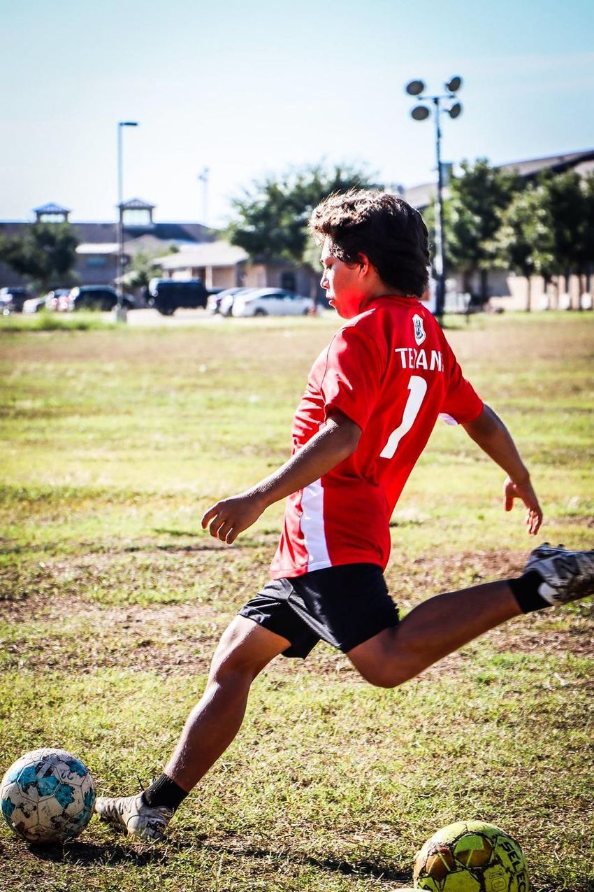 Player in a red shirt striking the ball during private training